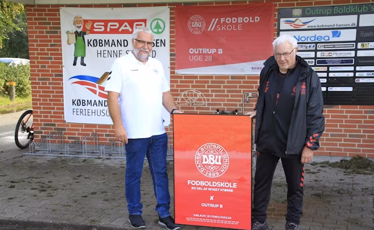 Hans Peder Pedersen fra DBU  overrækker jubilæums skiltet til  Arnfred Jessen fra Outrup Boldklub 